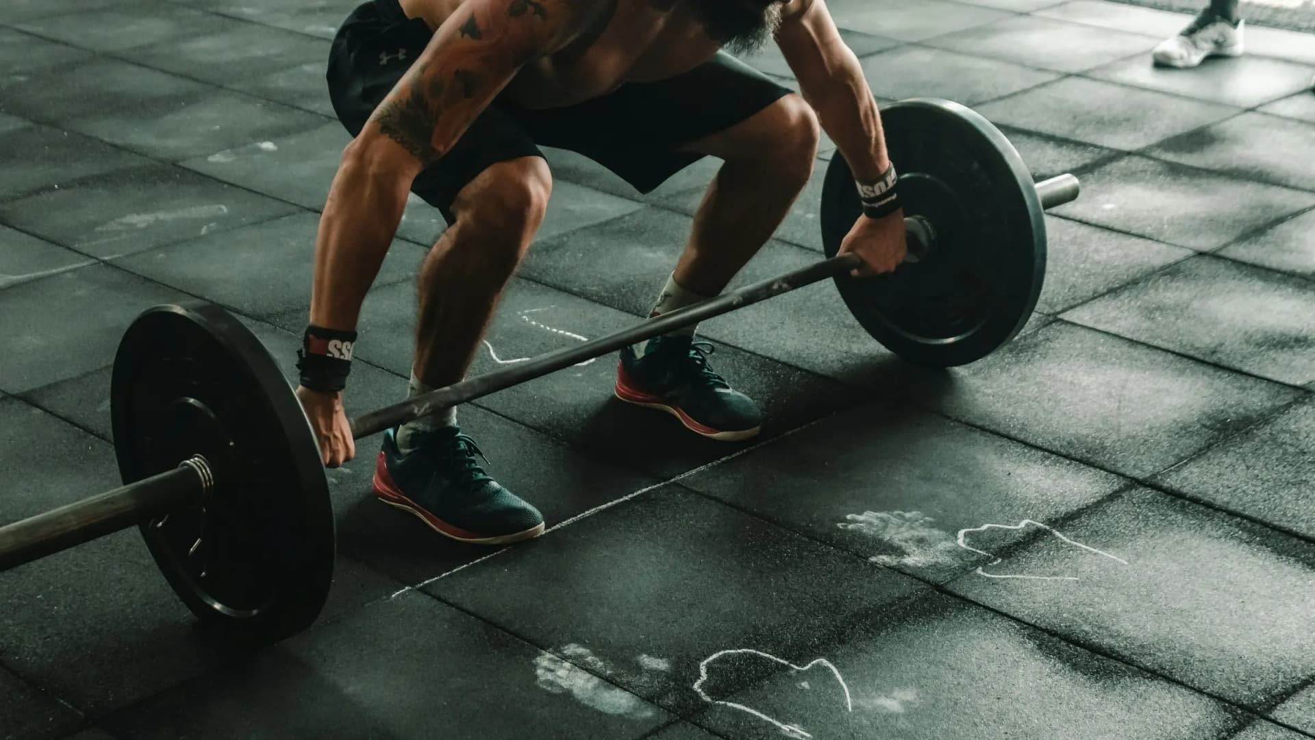 Atleta levantando una barra con discos en un box de CrossFit