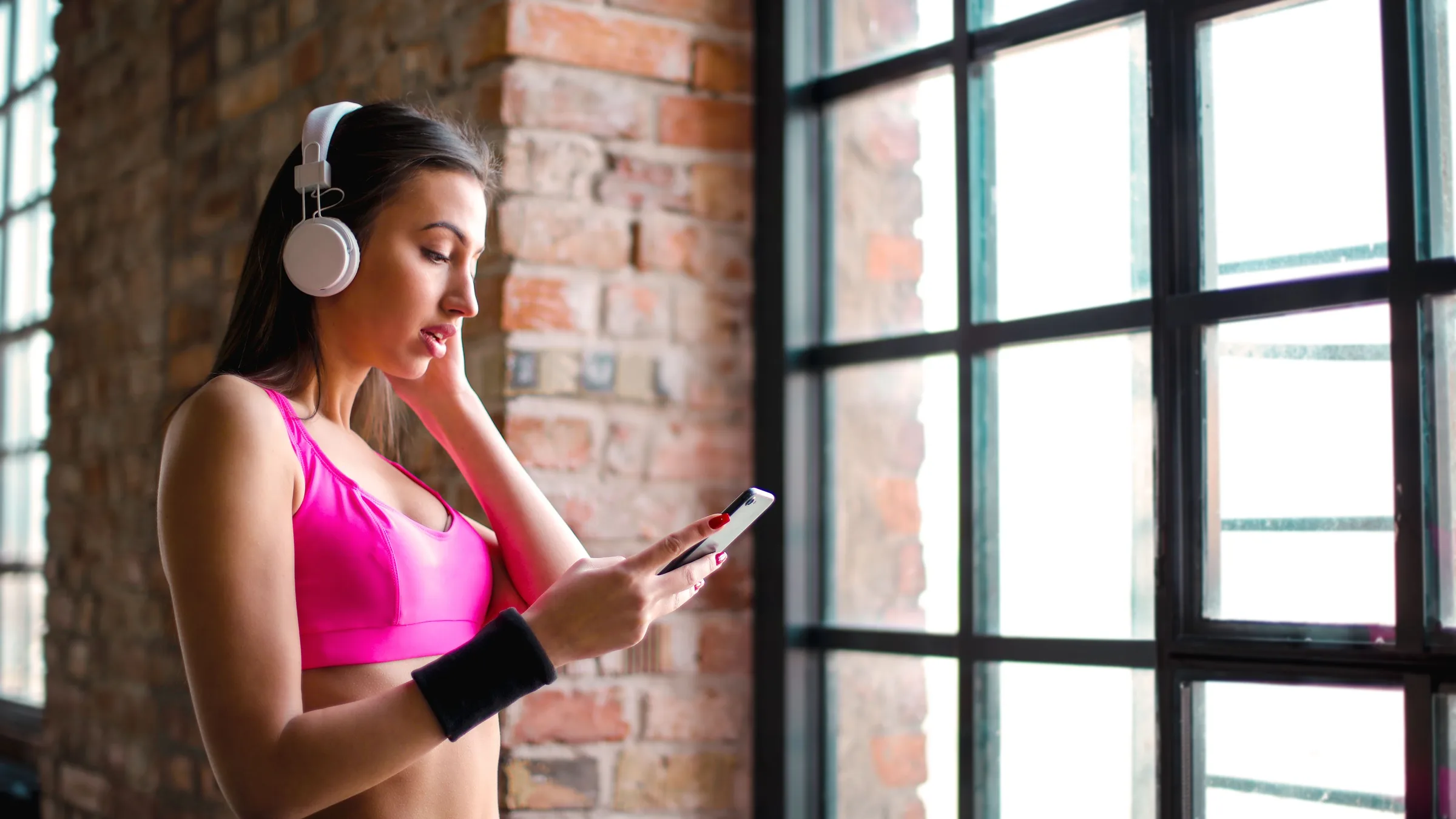 Persona en un gimnasio industrial mirando su teléfono